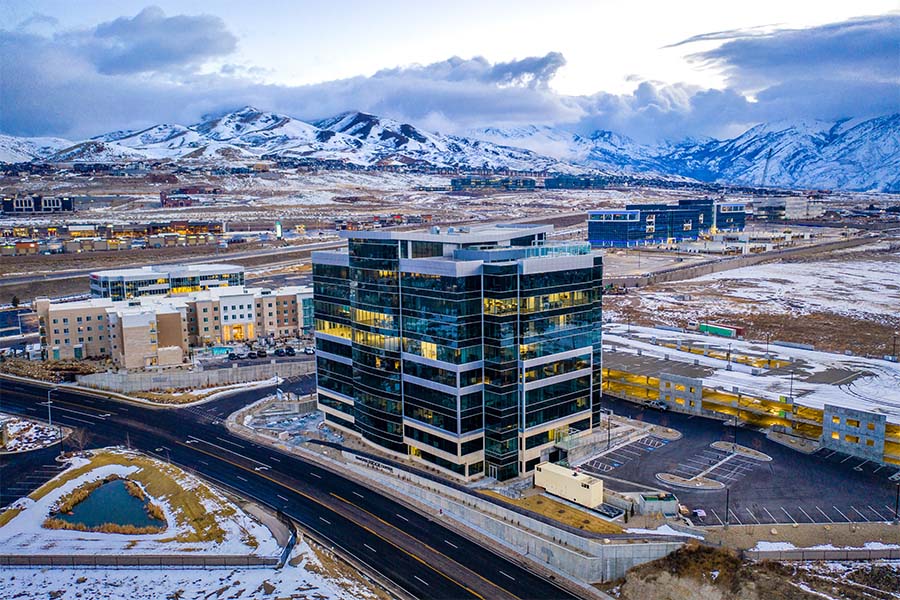 Business Insurance - View of Modern Glass Commercial Building and Surrounding Buildings in Lehi Utah Surrounded by Snowy Mountains During the Winter